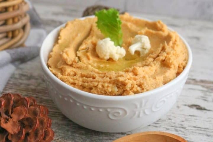 A bowl of roast cauliflower hummus with garnish