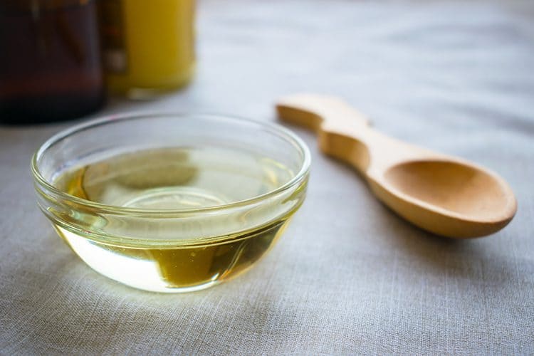 A bowl of MCT oil with a wooden spoon