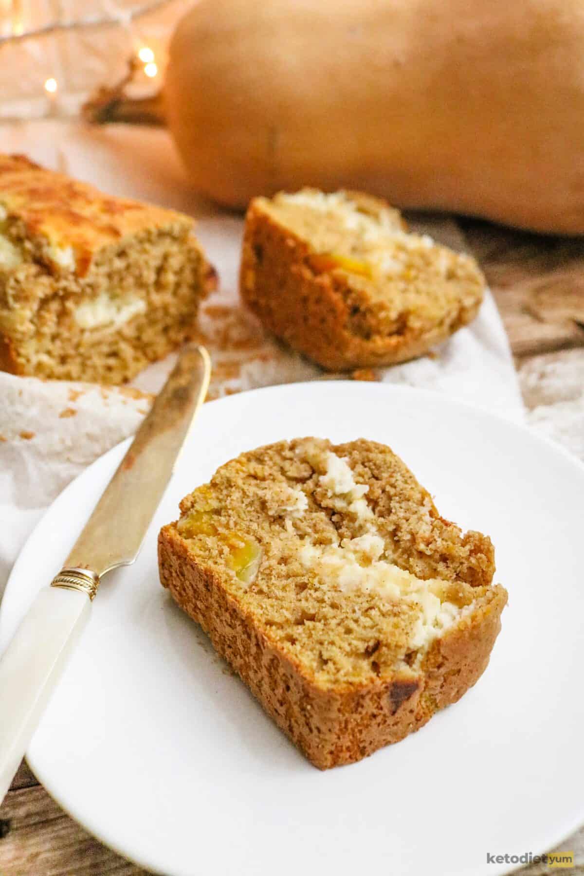 A slice of keto pumpkin bread with cream cheese filling served on a white plate