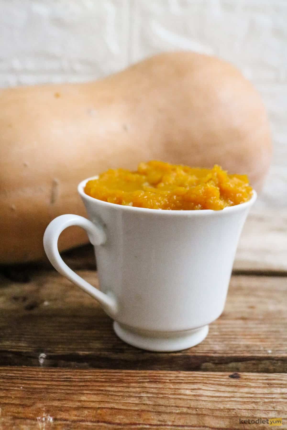 A white glass filled with pumpkin puree