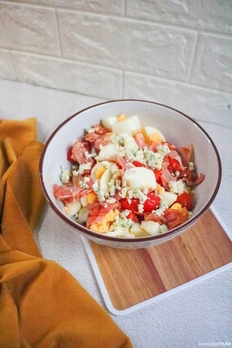 Iceberg lettuce wedge salad topping with bacon, eggs and blue cheese