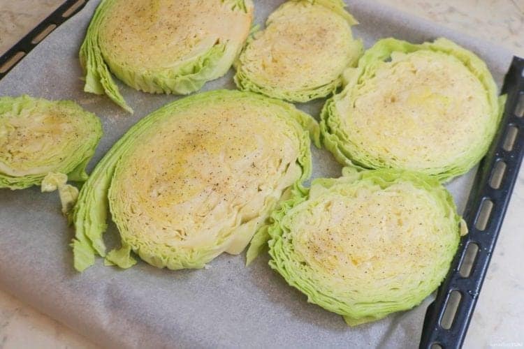 Seasoning the cabbage steaks before roasting