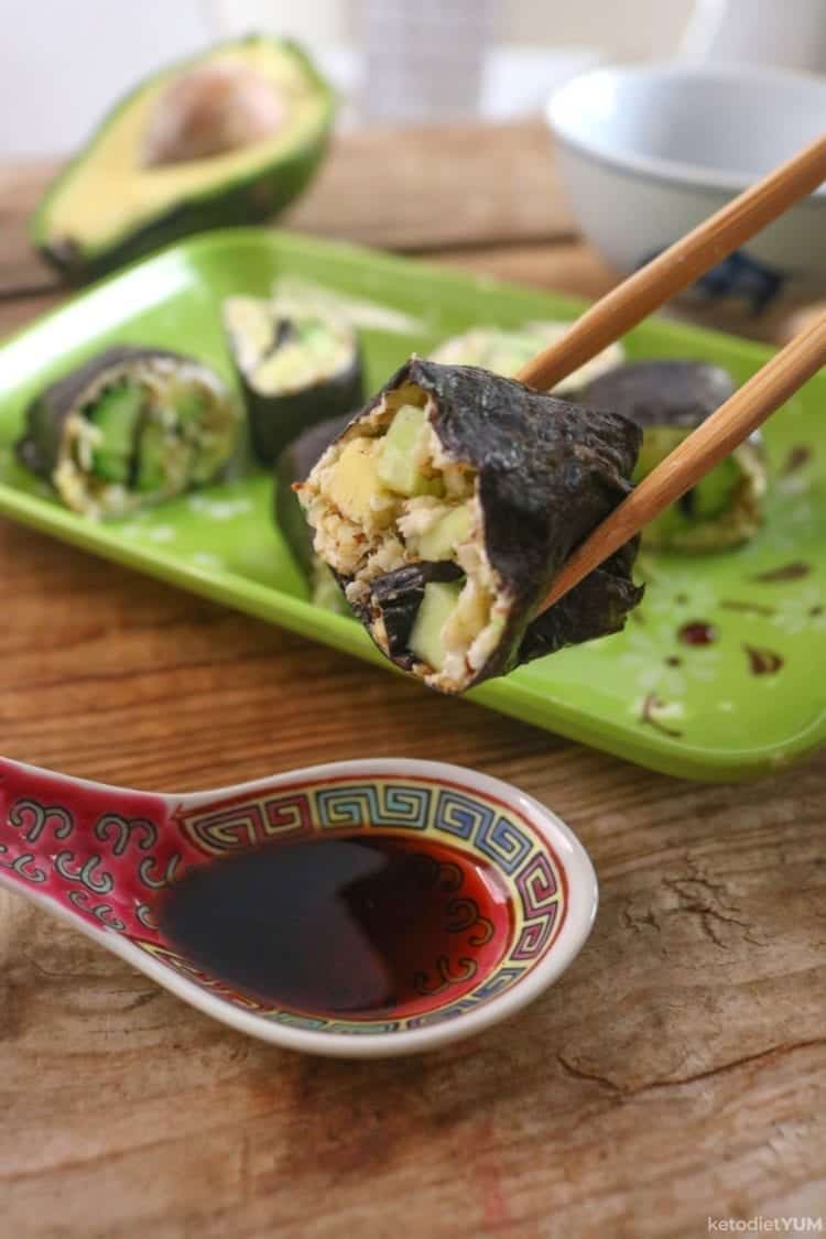 dipping vegetarian cauliflower rice sushi in gluten-free soy sauce
