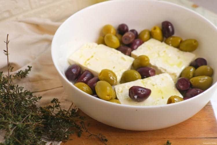 Sliced feta cheese and olives in a baking dish