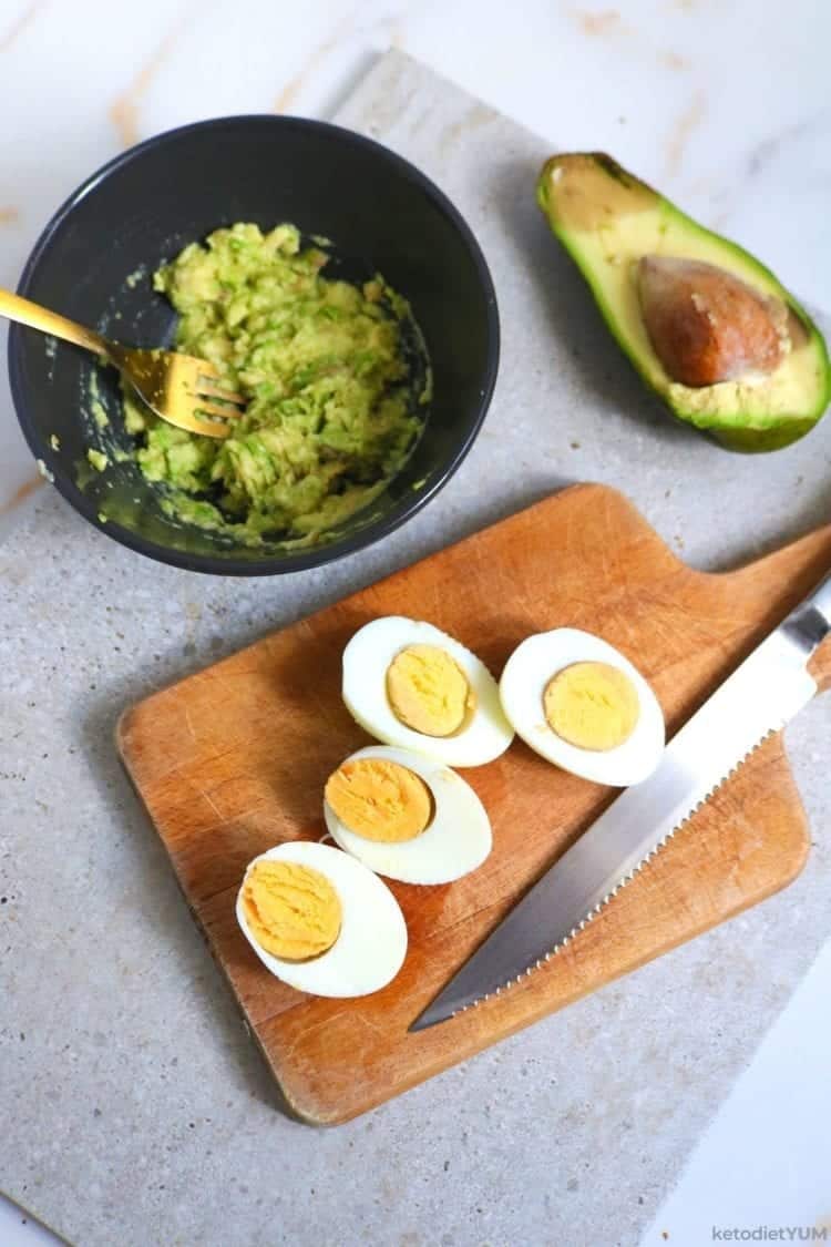 Sliced hard boiled eggs, avocado mashed and mixed with seasonings for keto sliders