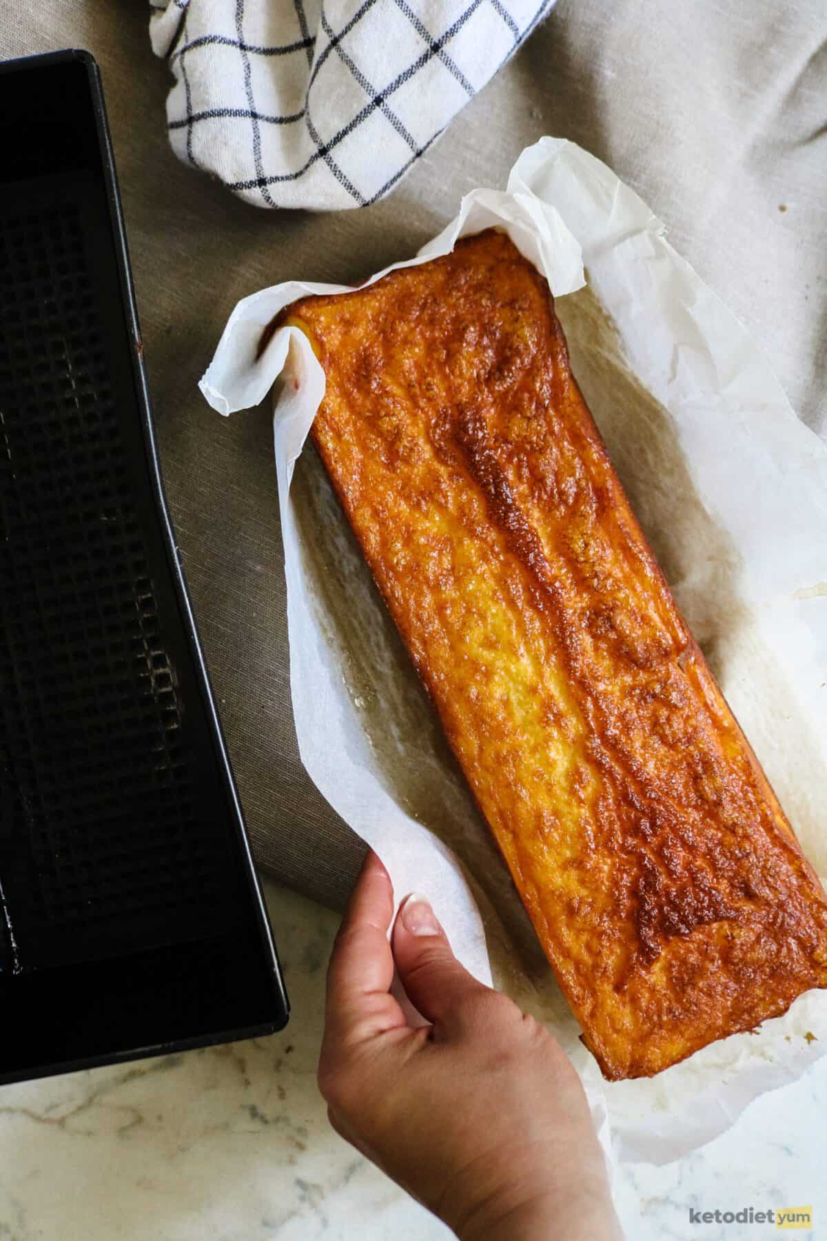 Golden keto egg loaf next to a loaf pan