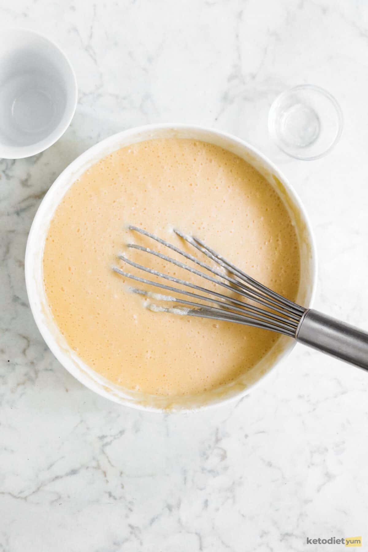 White bowl filled with batter with a whisk inside