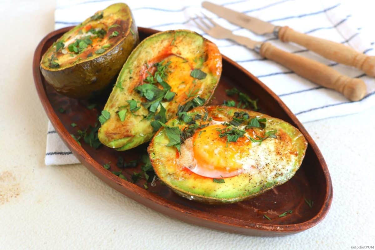 Avocado egg boats fresh from the oven sprinkled with herbs