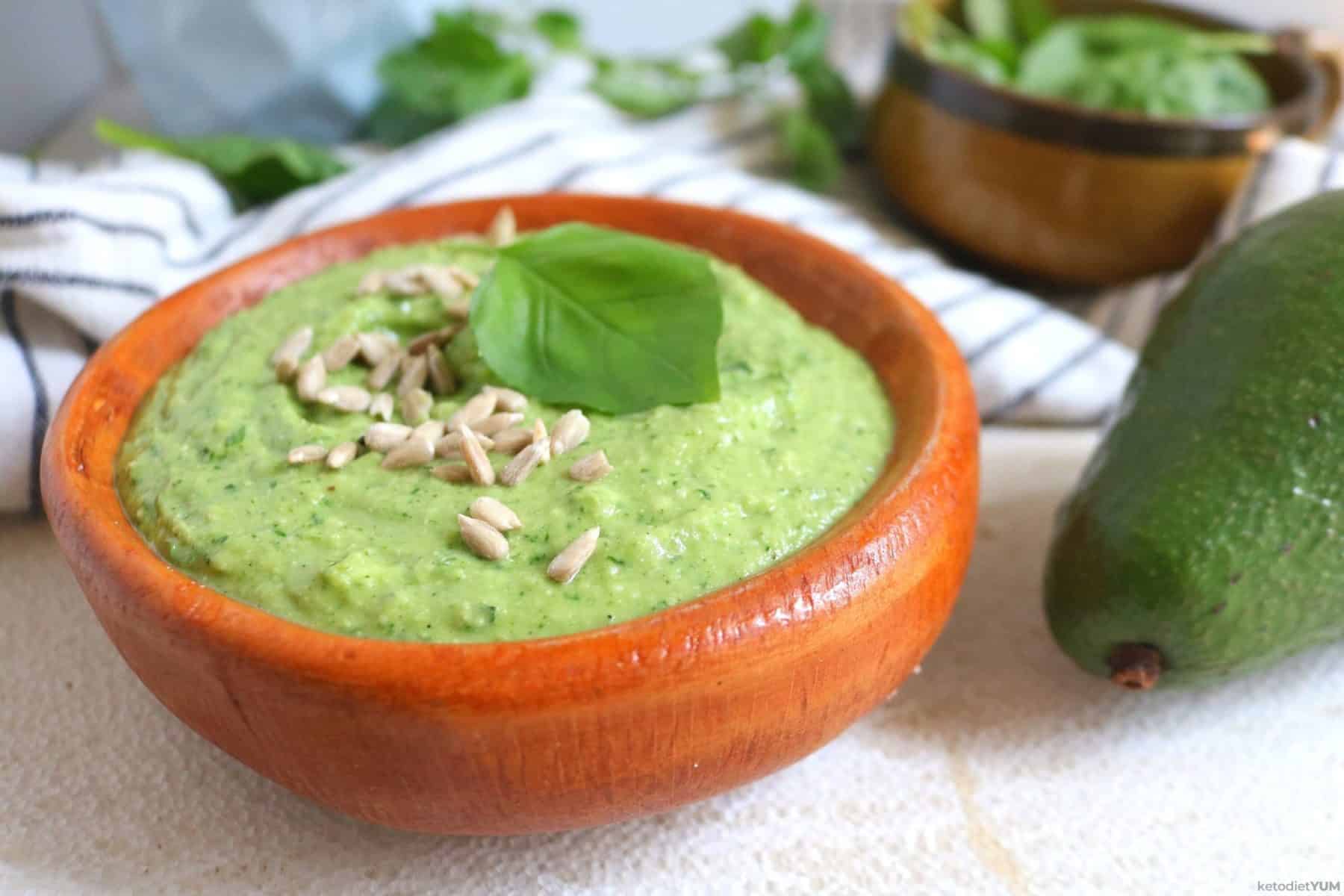 A bowl of avocado pesto sauce made with basil and spinach