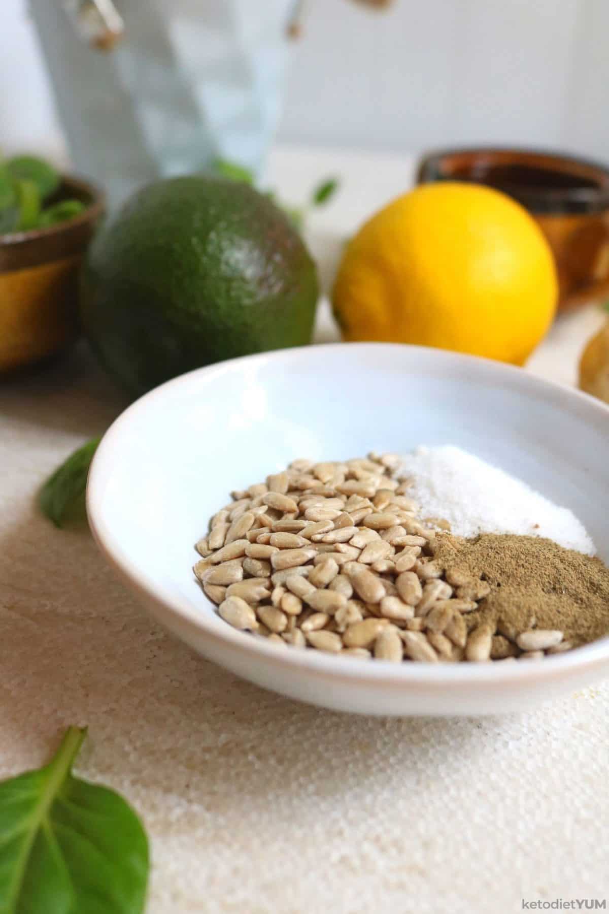 A bowl of sunflower seeds, salt and black pepper