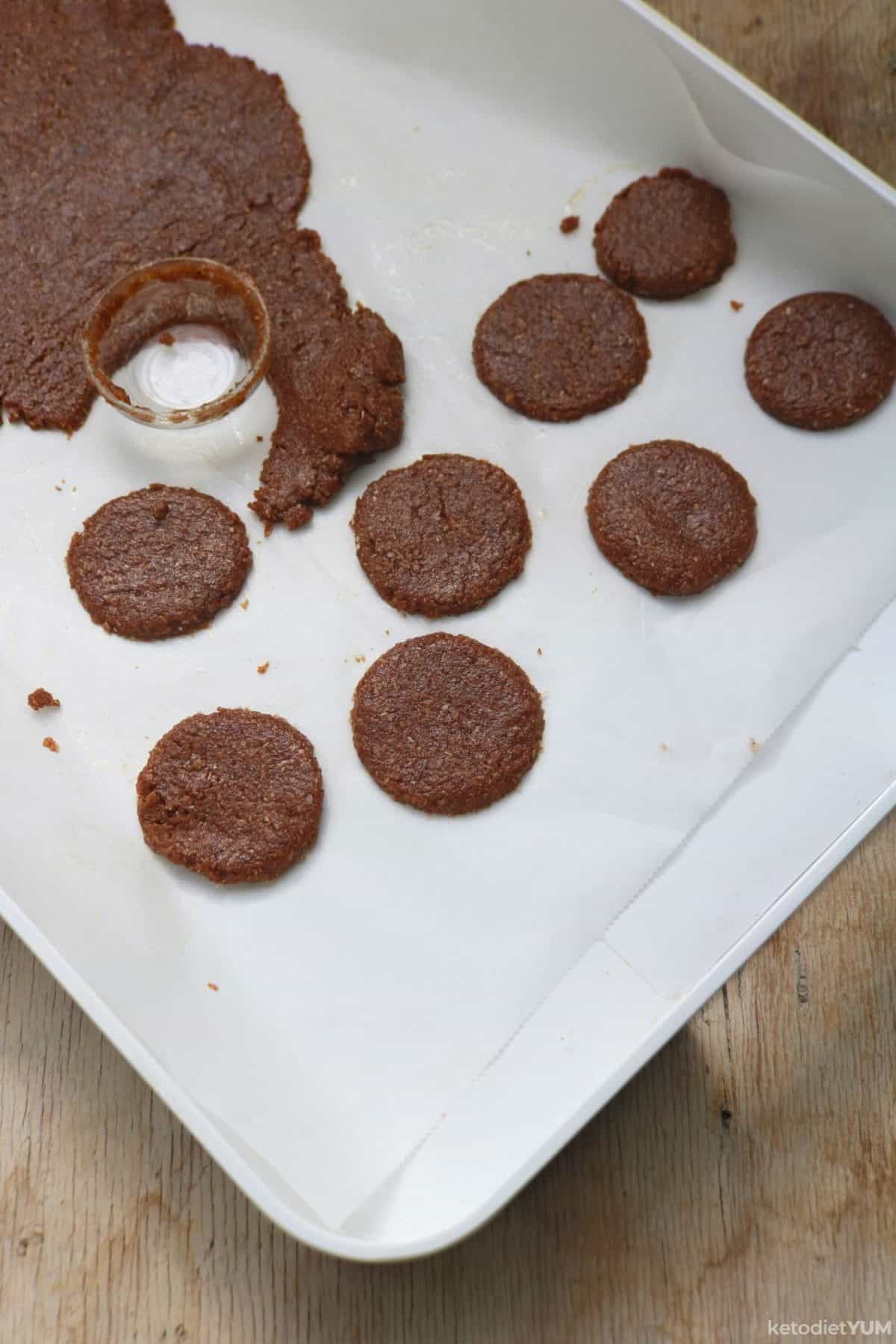 Cookie dough on a baking sheet cut into circles and ready to bake