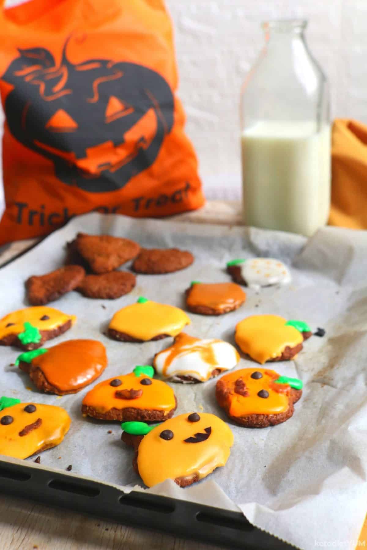 Halloween keto pumpkin cookies with different colored icings ready to enjoy