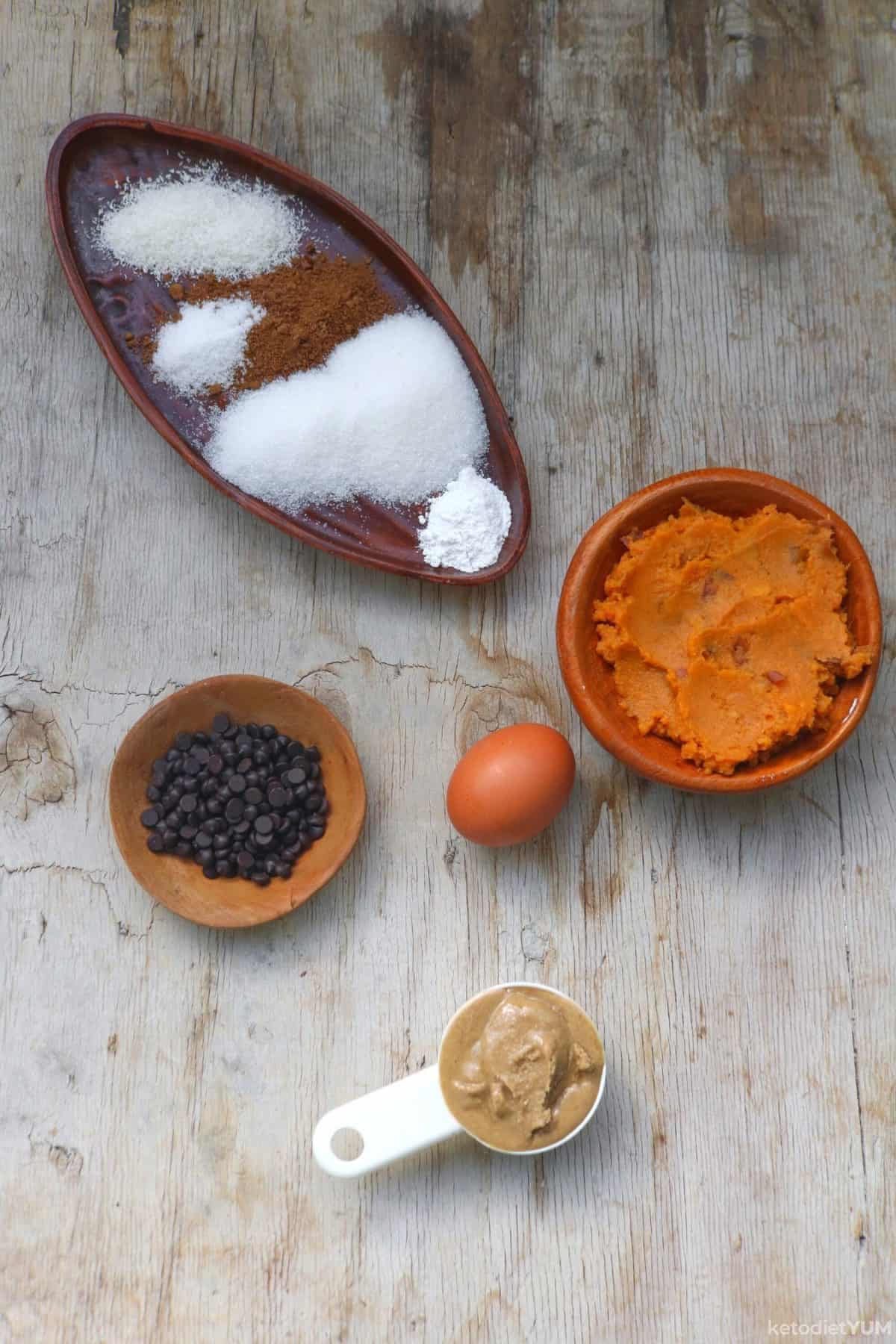 Photo of ingredients including chocolate chips, an egg, pumpkin puree, peanut butter and various dry ingredients