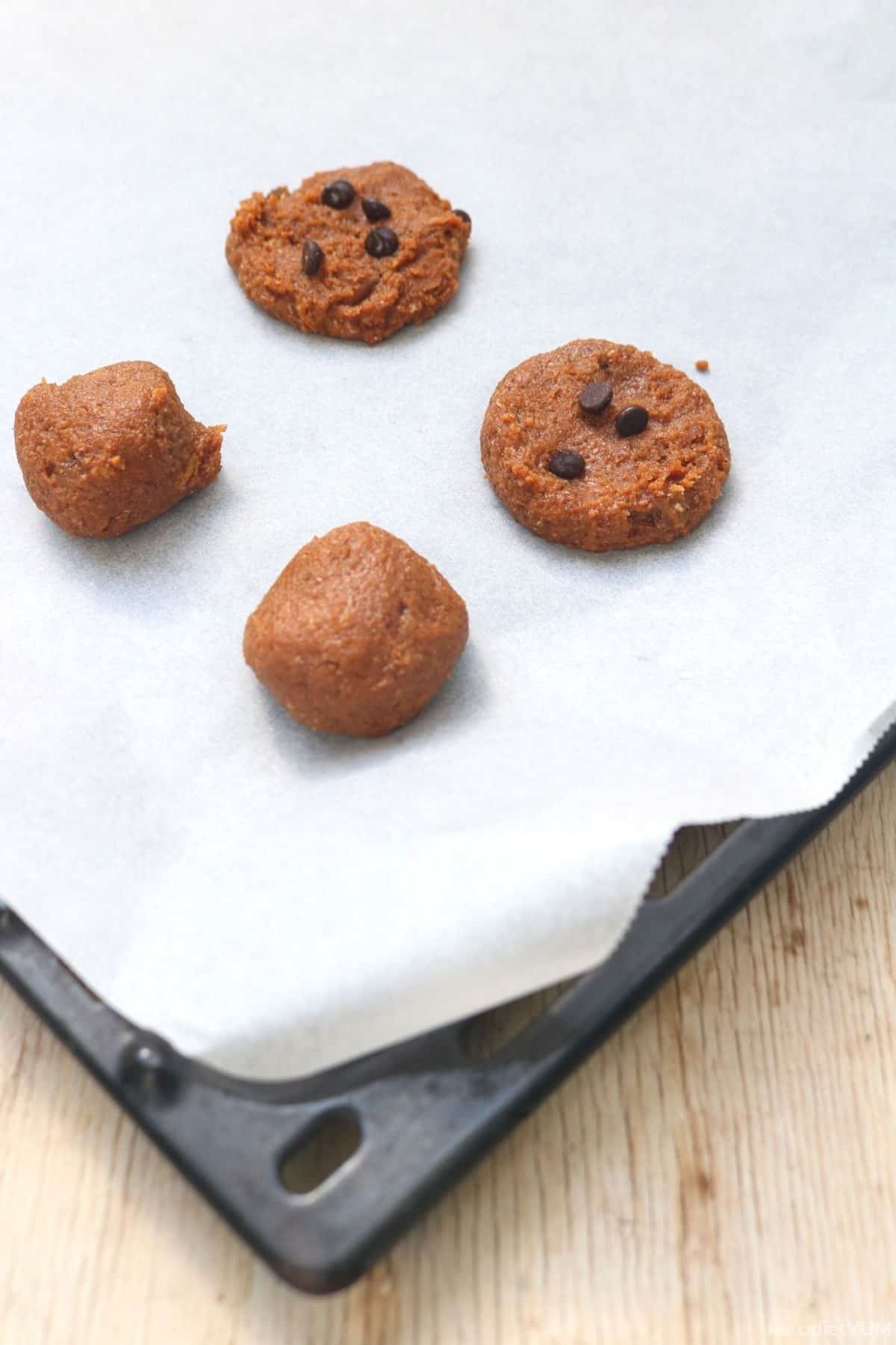 Cookie dough being placed on a lined baking sheet before baking