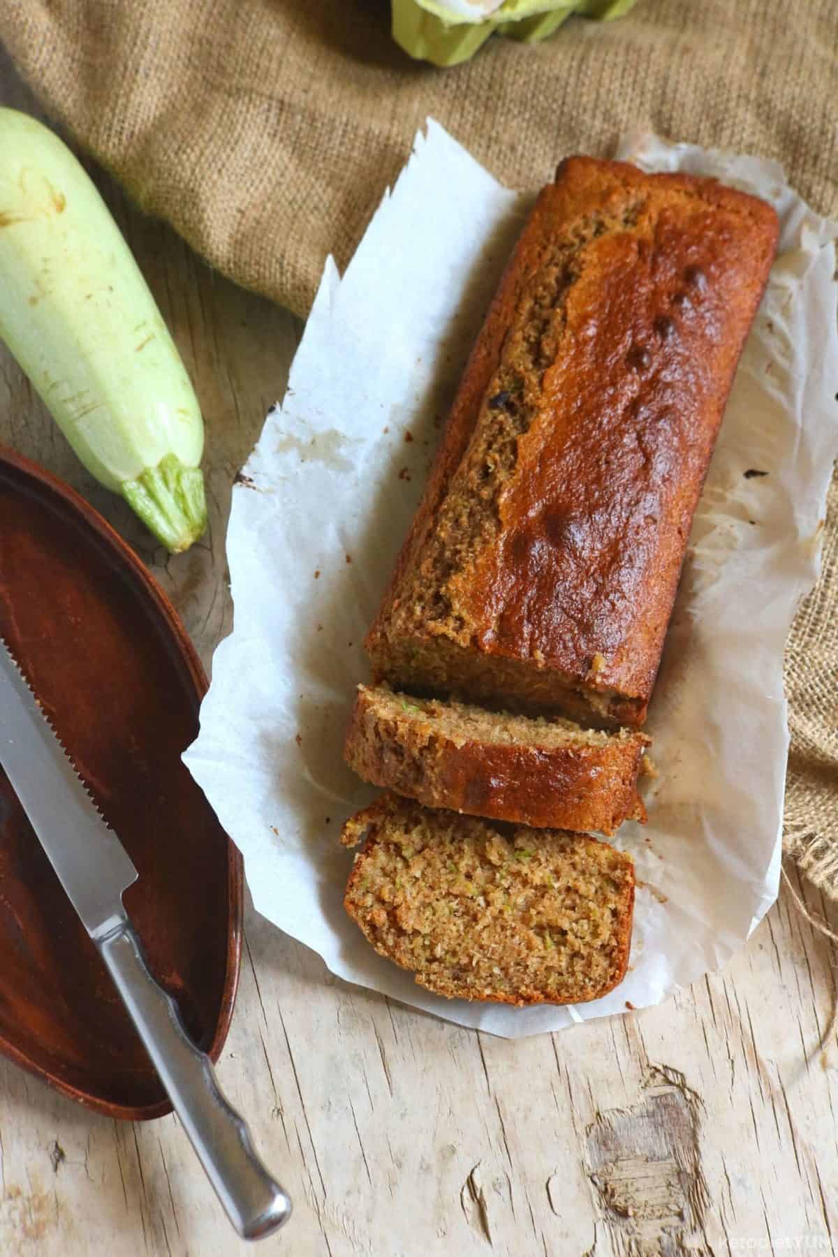 Keto zucchini bread sliced next to a whole zucchini