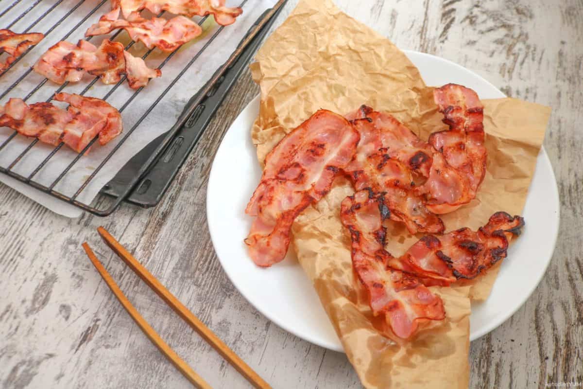 Delicious oven baked bacon resting on parchment paper