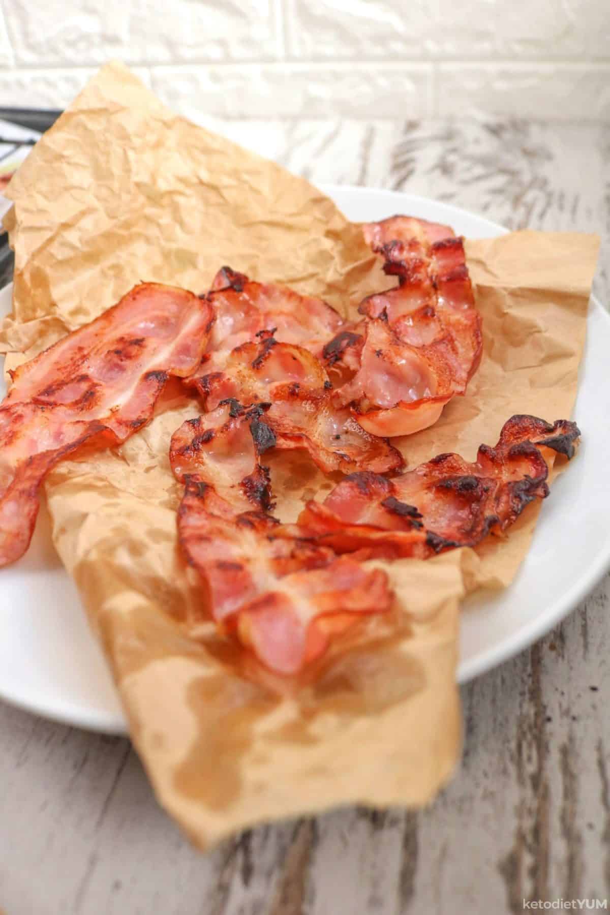 Delicious crispy oven baked bacon strips resting to reach room temperature and become even more crispy