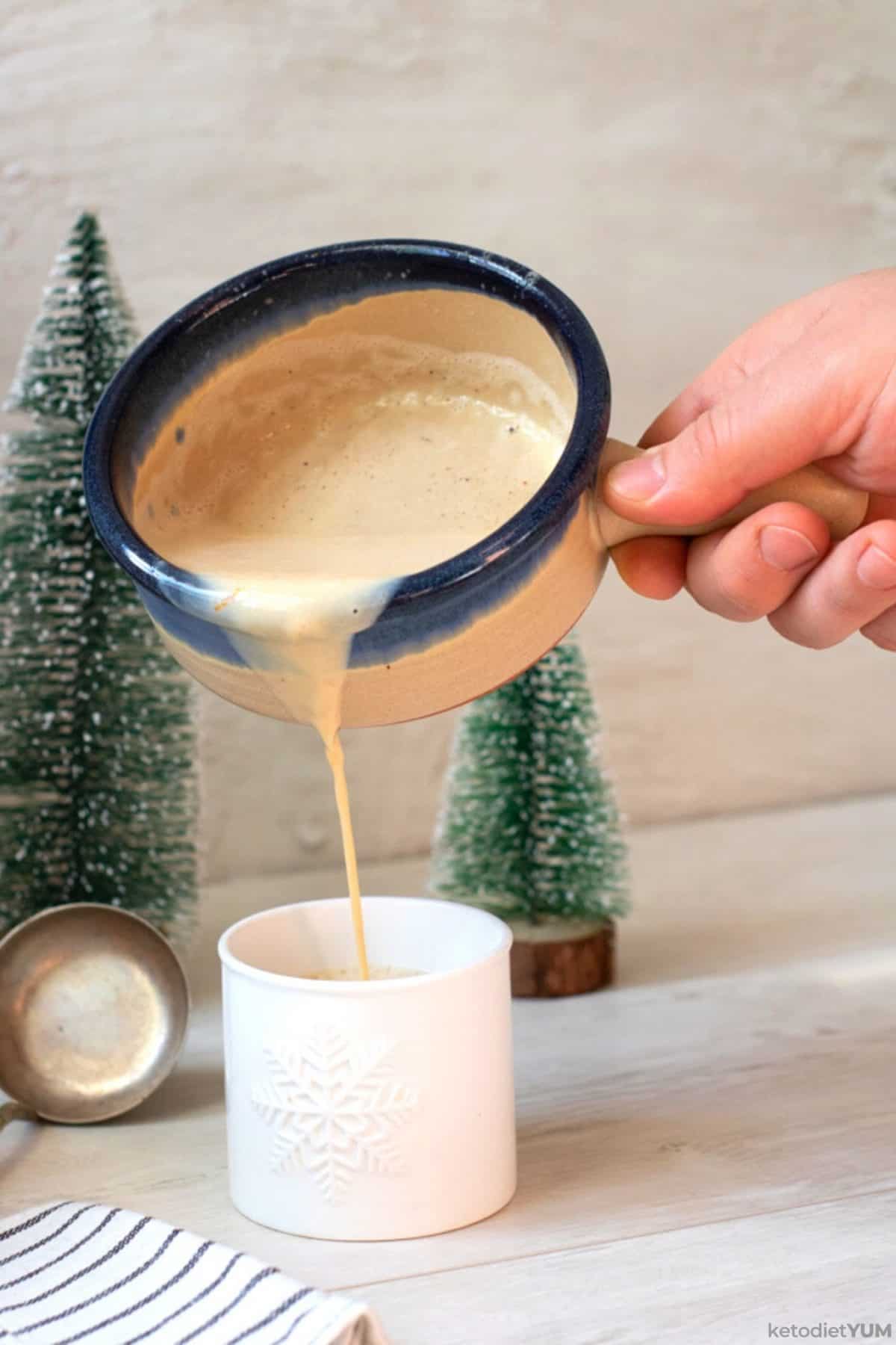 Pouring low carb eggnog cocktail into a mug