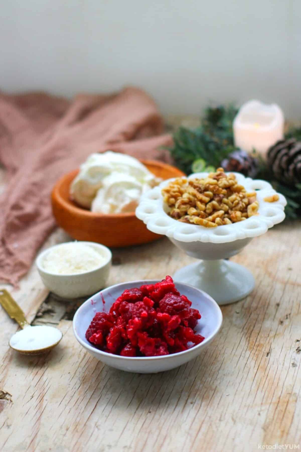 Ingredients on a table including cream cheese, walnuts, raspberries, coconut and Erythritol