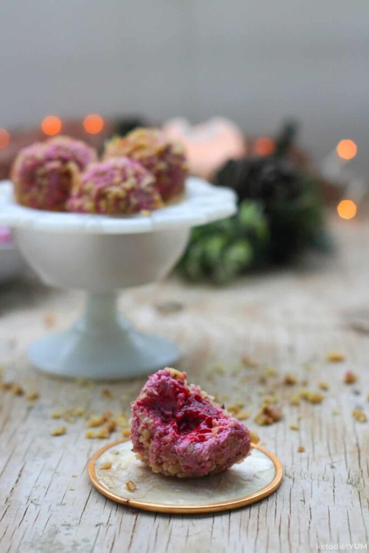 A raspberry cheesecake bite with a crunchy walnut outside and fresh raspberry inside