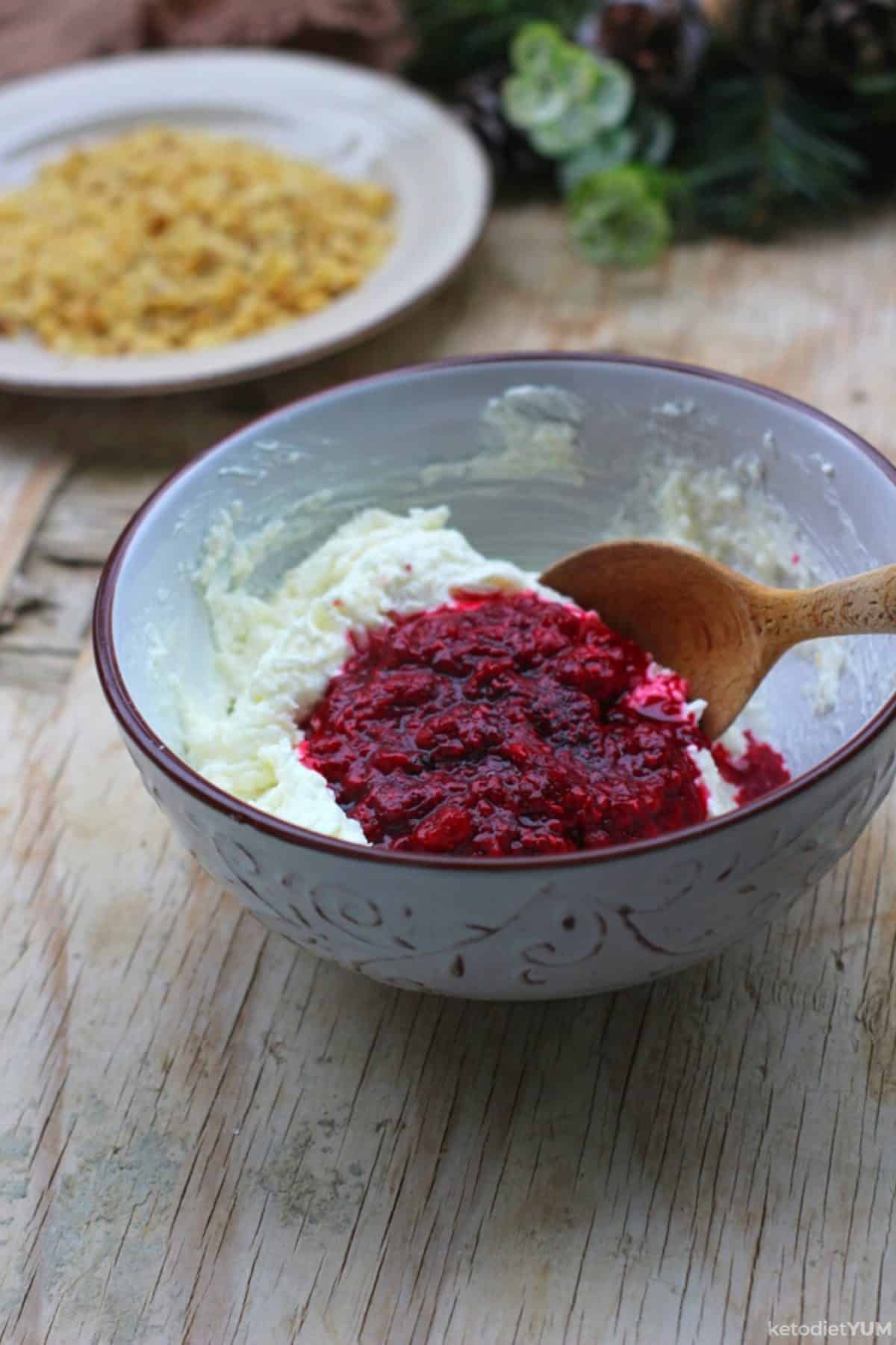 A mixing bowl with cream cheese, raspberries and Erythritol
