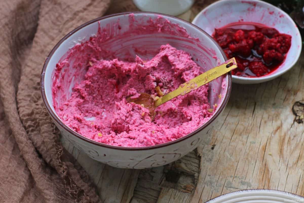 Crushed raspberries, cream cheese, Erythritol and coconut in a mixing bowl ready to refridgerate