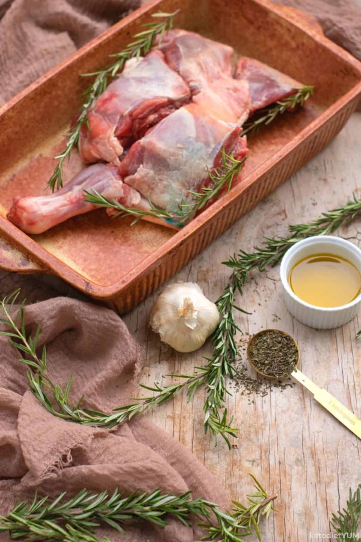 Raw leg of lamb with garlic, rosemary, olive oil and seasonings ready to bake