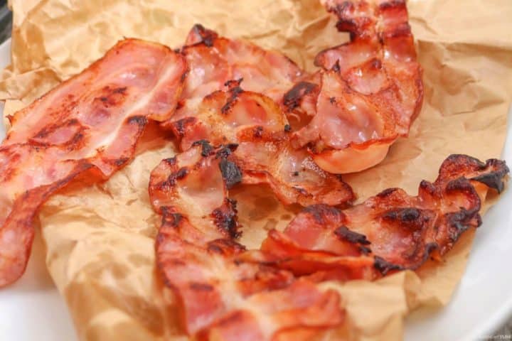 Placing the bacon slices on paper to remove excess grease and allow to cool to room temperature