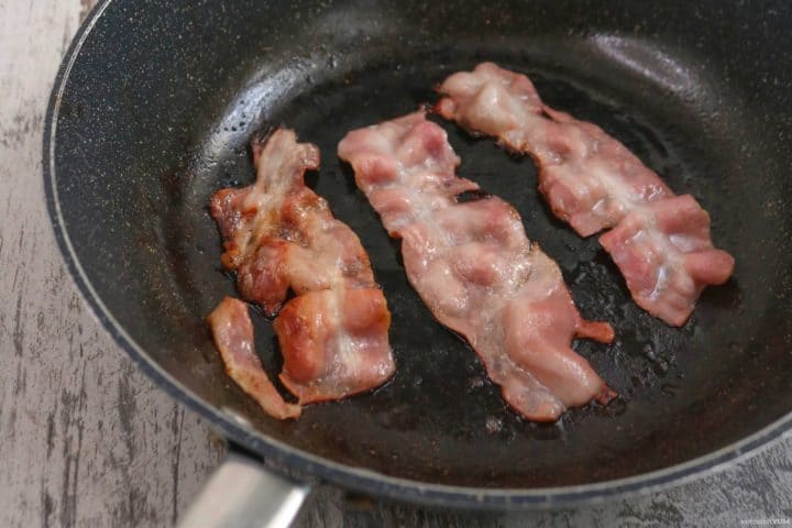 Arranging bacon slices on a cold pan ready to cook over a low heat