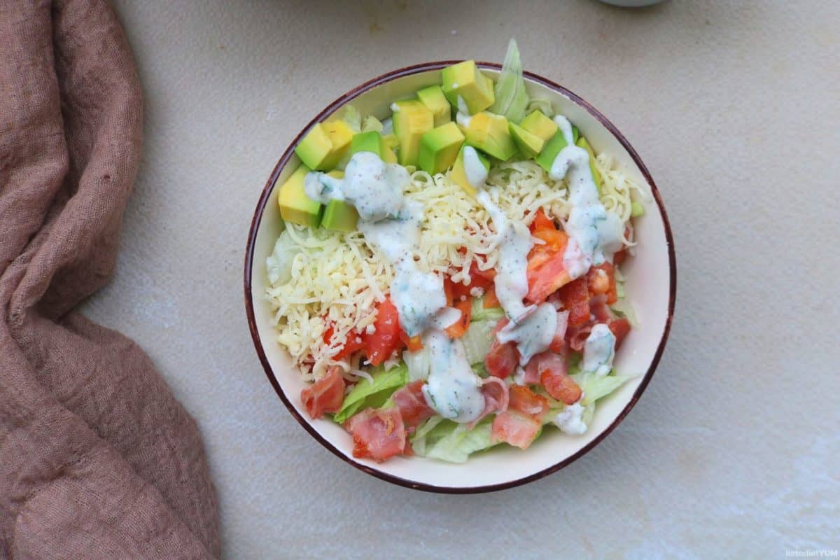 Delicious low carb BLT salad with avocado and gouda cheese, drizzled with a homemade dressing and ready to eat