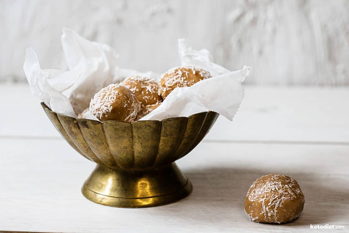 No bake peanut butter energy balls in a serving bowl sprinkled with desiccated coconut