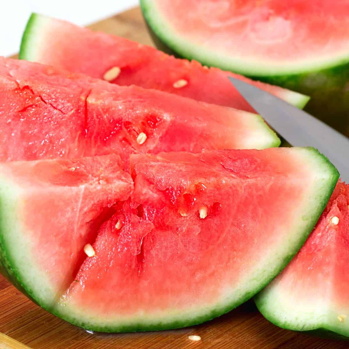 watermelon on a chopping board with a knife