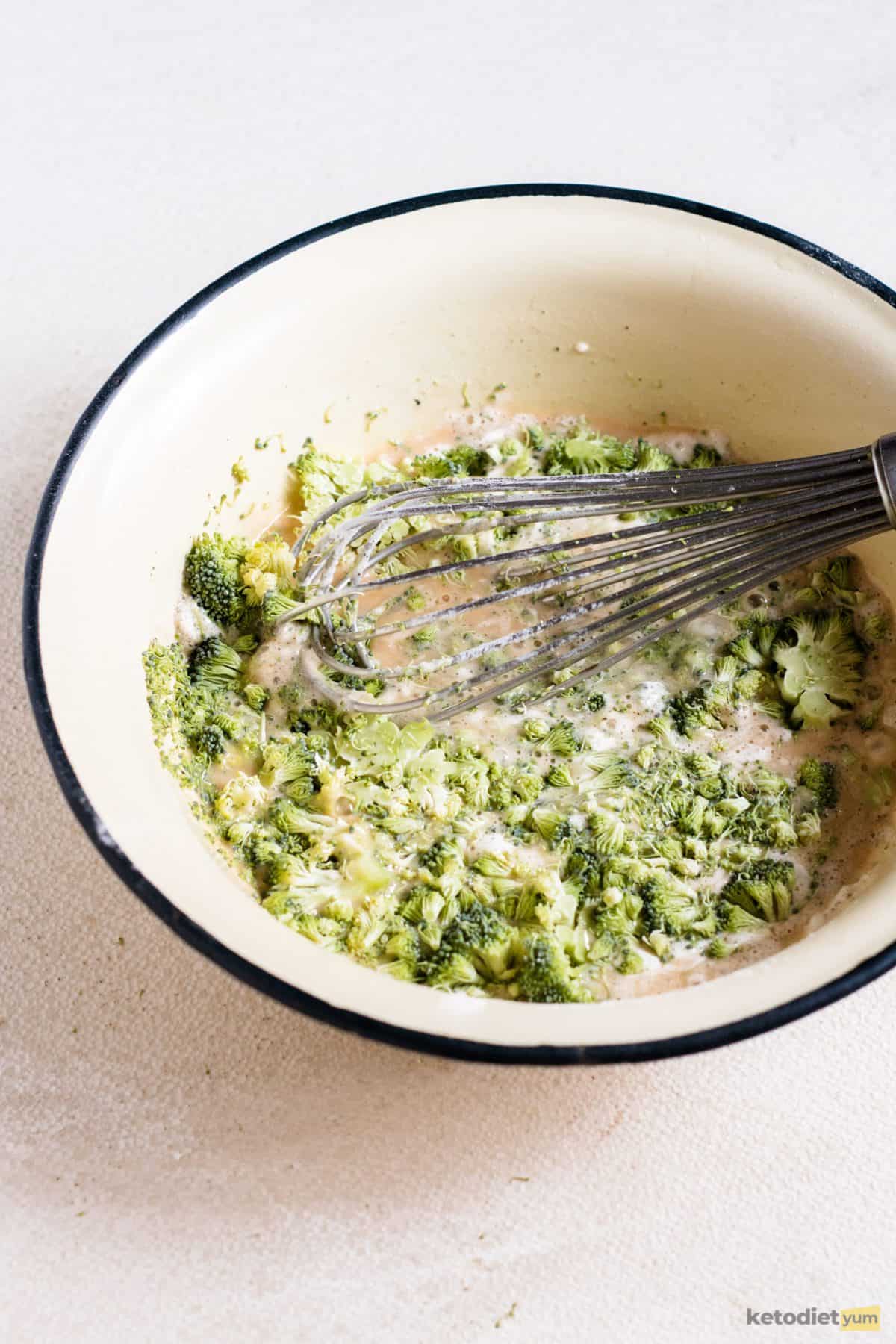 Mixing ingredients in a bowl to make a low carb broccoli quiche