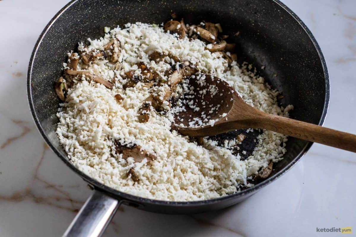 Easy Creamy Cauliflower Mushroom Risotto (Keto) Adding cauliflower rice to a pan of sautéed mushrooms and celery