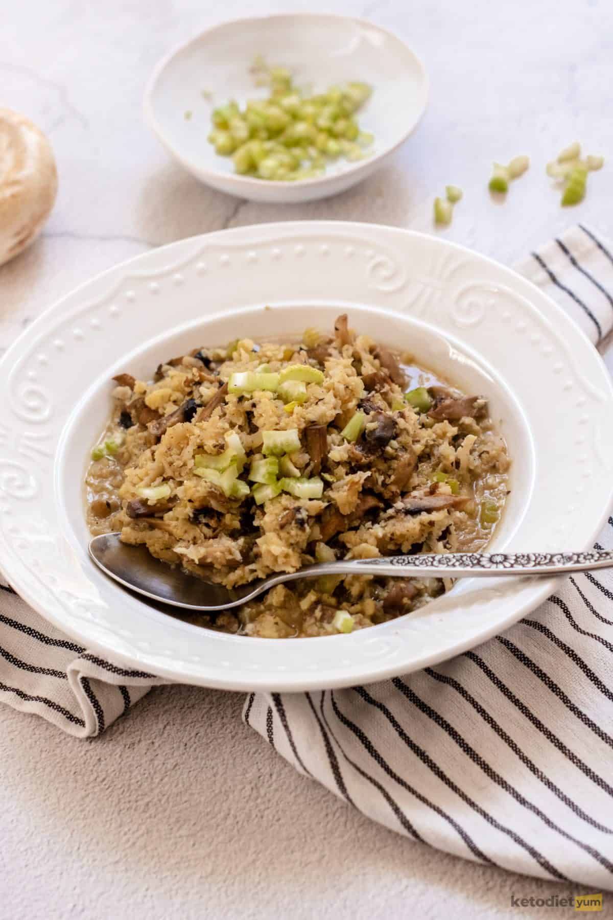 A healthy cauliflower risotto served on a white plate with a fork