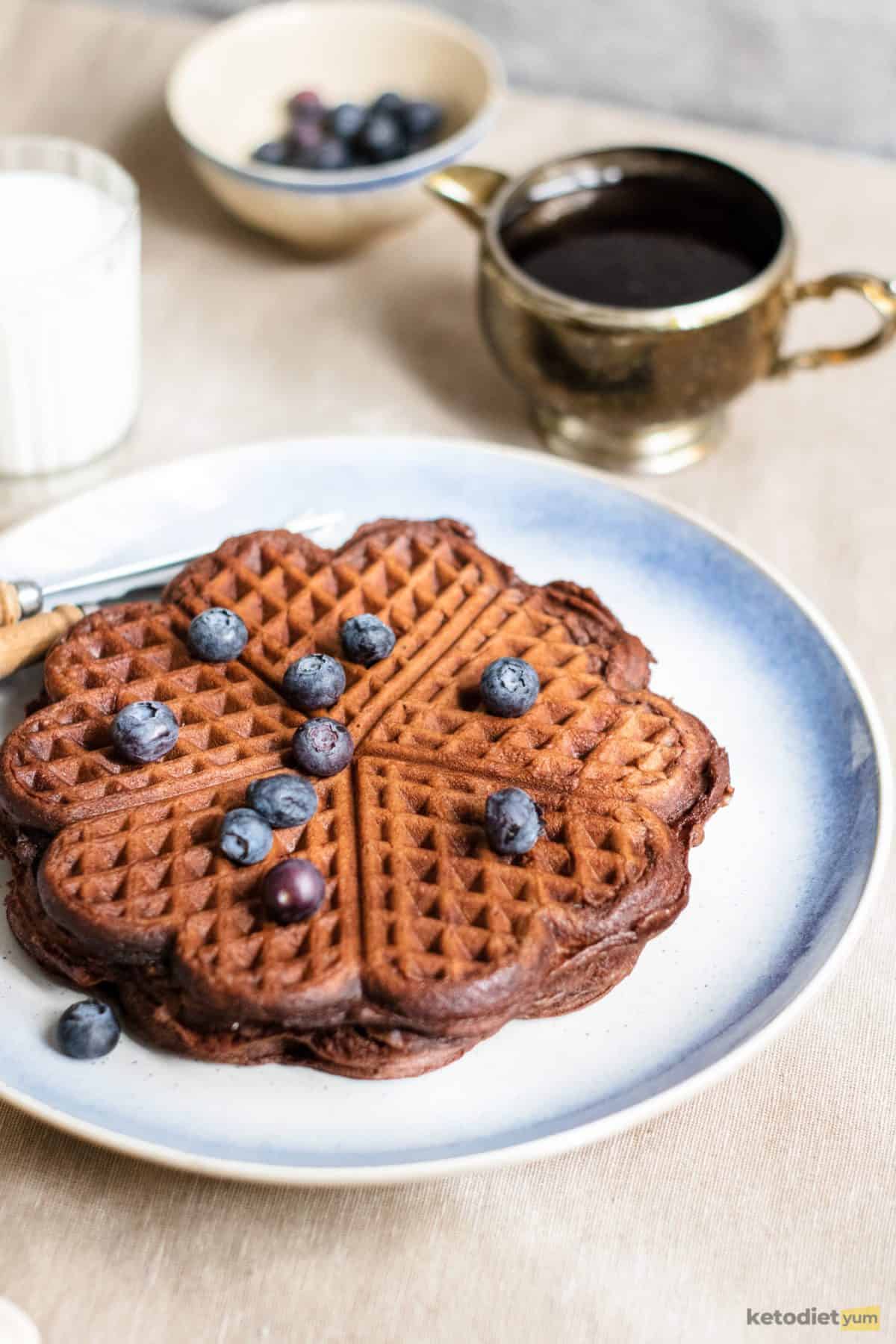 Low carb chocolate chaffles on a plate topped with blueberries and ready to eat