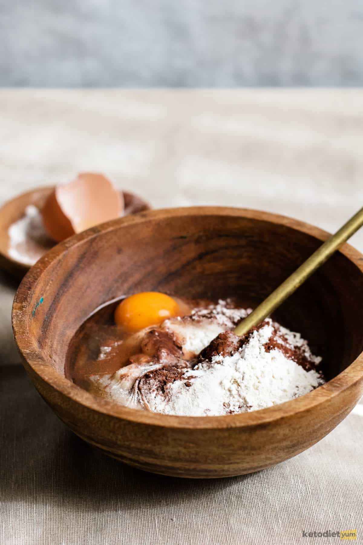 Keto Chocolate Chaffle Recipe Combining egg, coconut flour, Erythritol, cocoa powder, baking powder and salt in a mixing bowl.