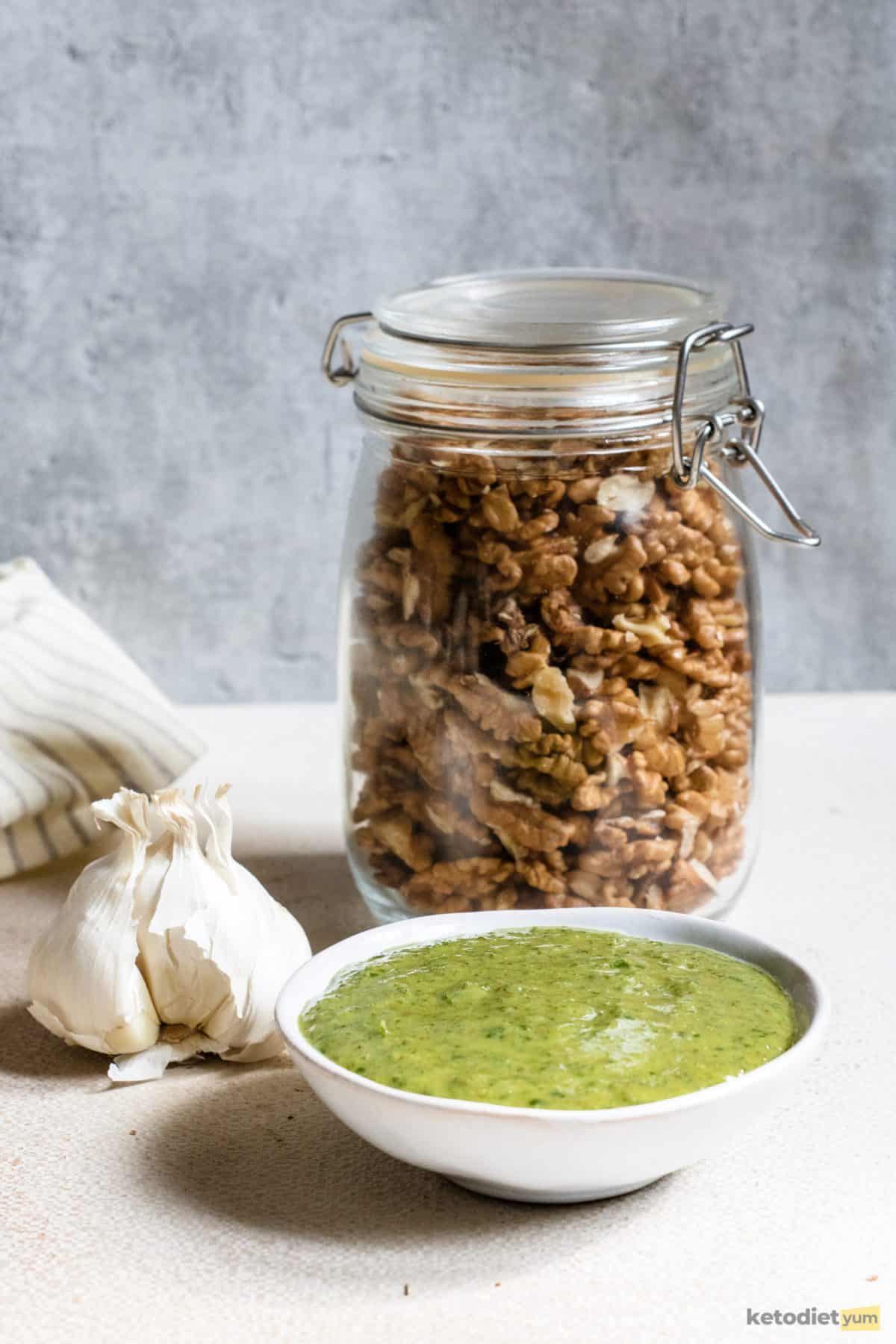 A simple homemade pesto in a white bowl made with parsley, walnuts, olive oil, parmesan, garlic, salt and pepper