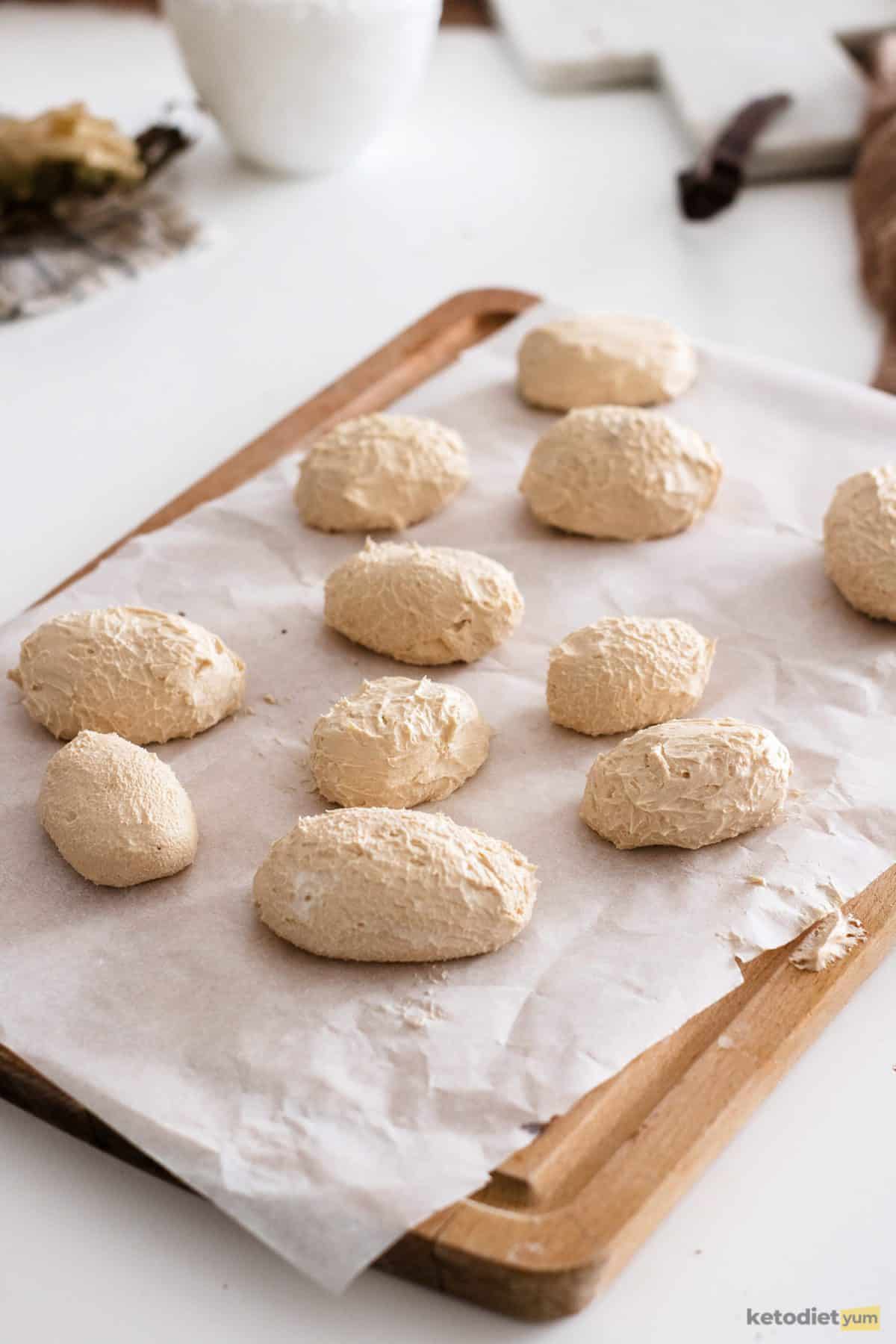 Creamy peanut butter filling shaped into eggs on a lined tray