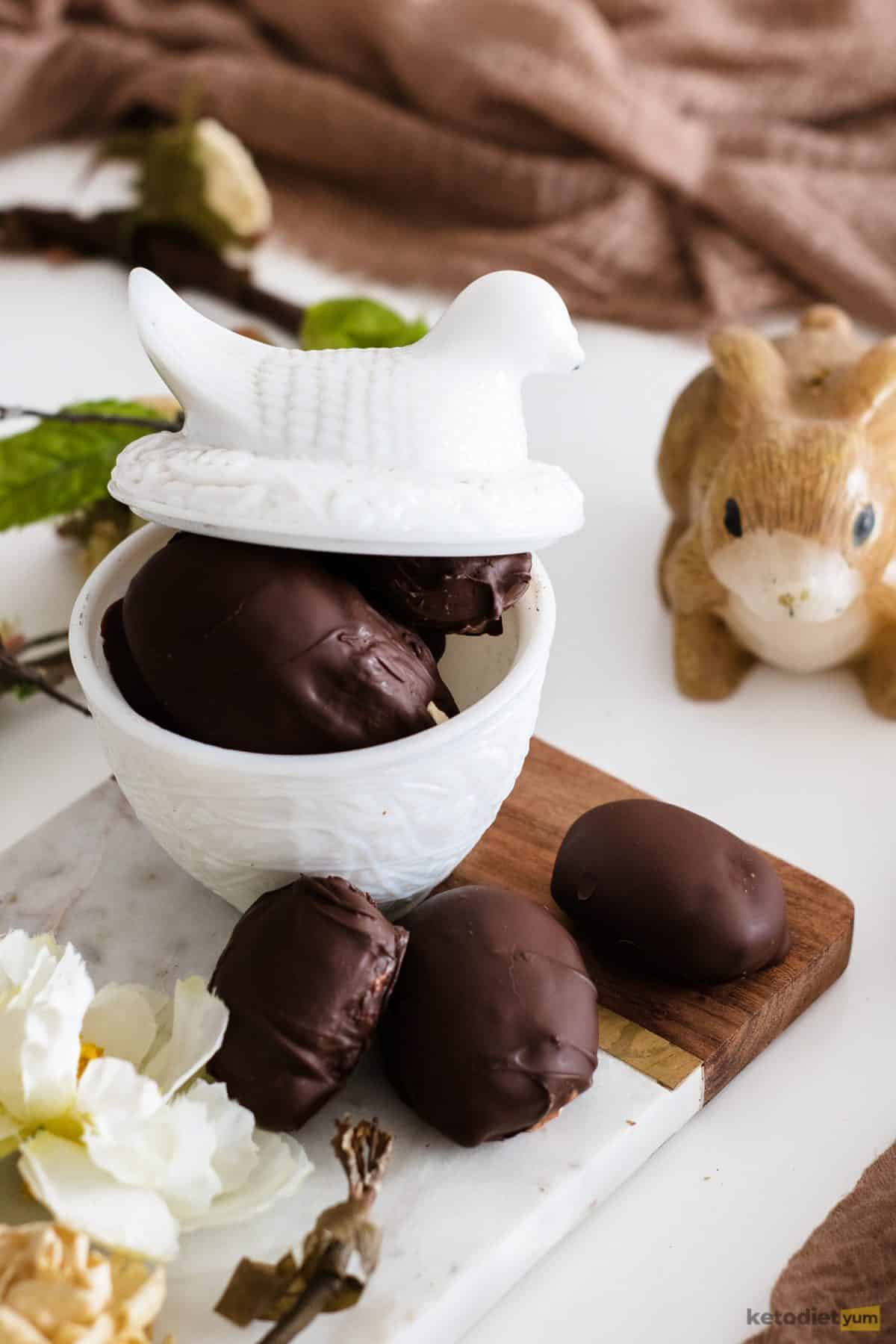 Keto Easter eggs with a creamy peanut butter filling in a bowl with a rabbit for decoration