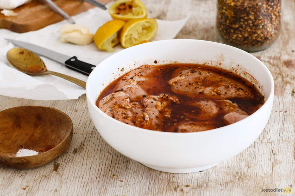 Chicken breasts in a large mixing bowl marinating in a homemade peri peri sauce