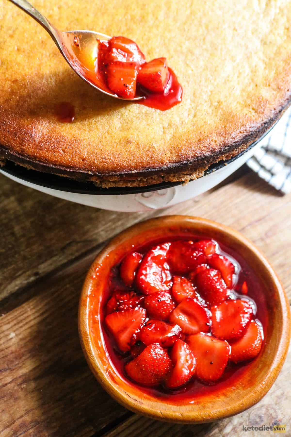 Spooning a strawberry sauce over the top of a keto cream cheese tart
