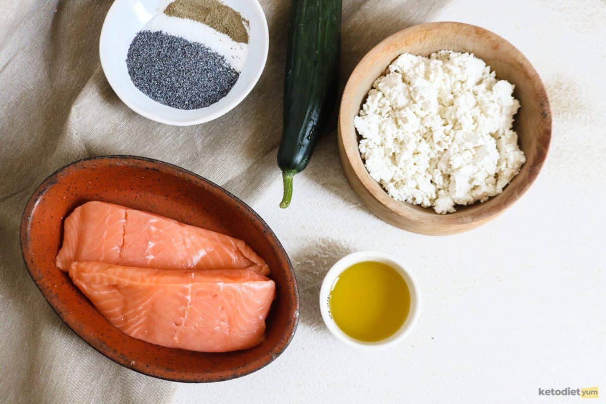 Healthy ingredients on a table including salmon fillets, poppy seeds, olive oil and goat cheese