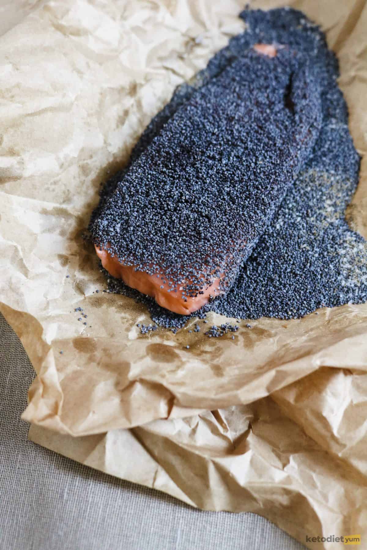 Coating salmon fillets with poppy seeds