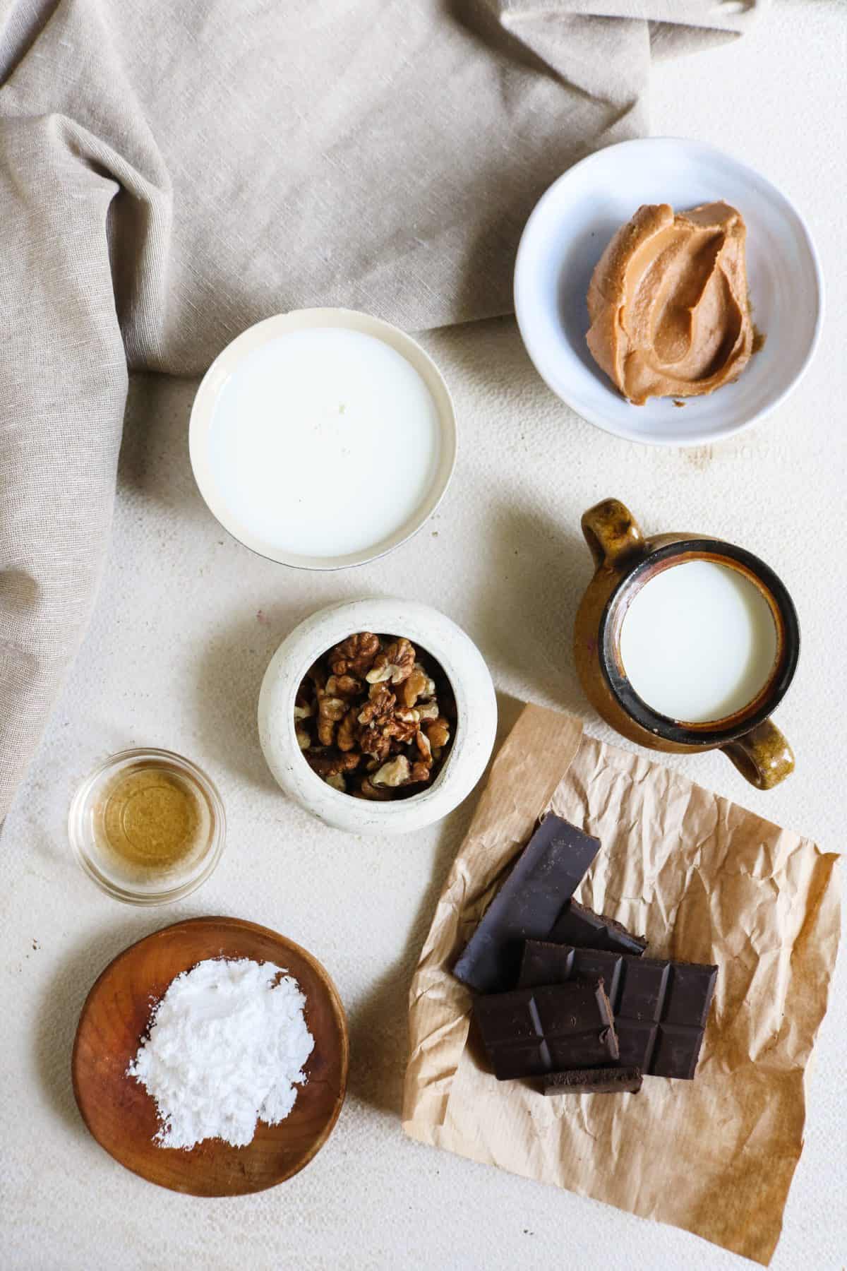 A birds eye view of ingredients arranged on a table that are used to make a keto cookies and cream smoothie