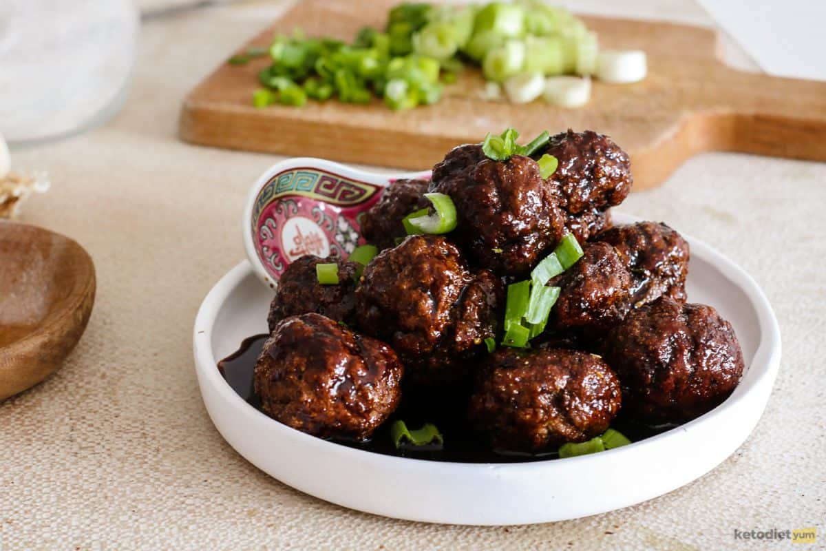 Quick and easy keto Kung Pao meatballs in a sticky sauce garnished with green onion