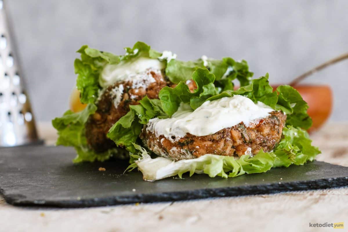 Salmon burgers served between lettuce leaves with a generous dollop of mayonnaise