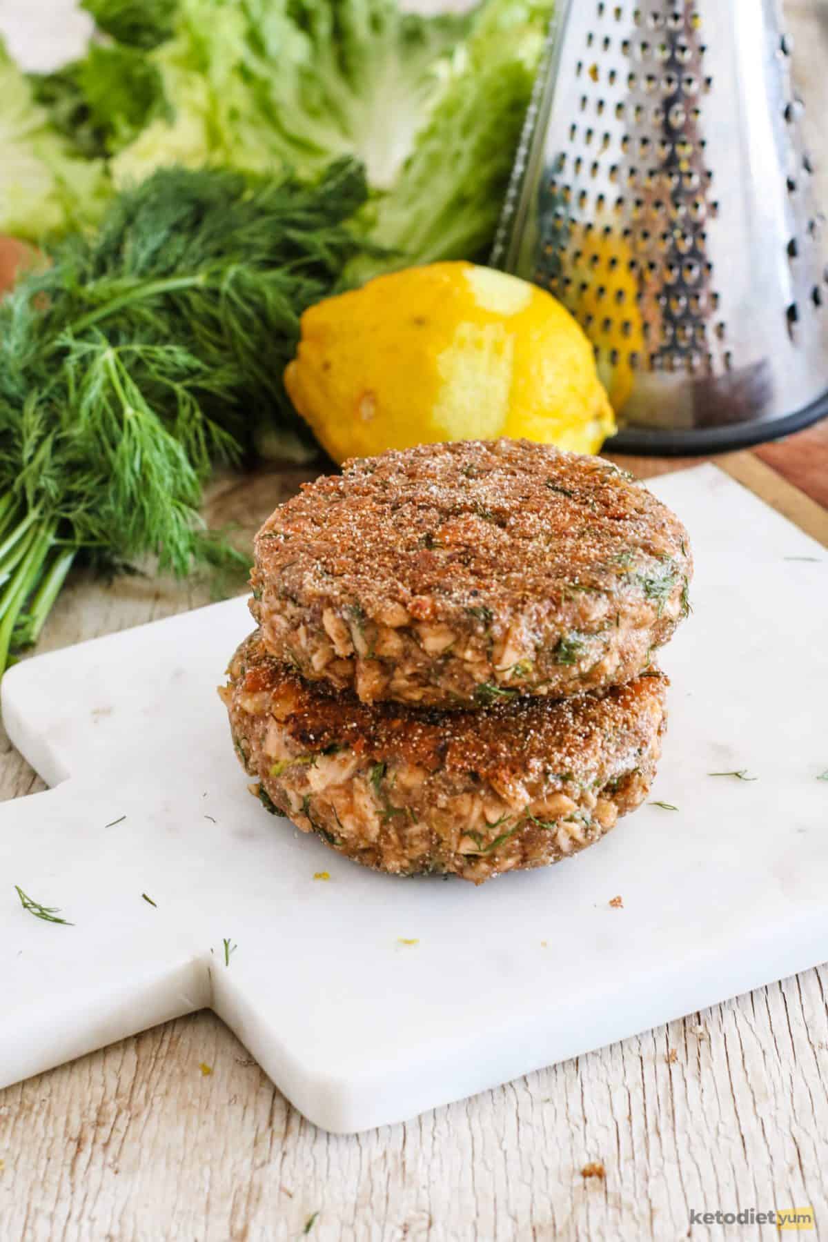 Golden salmon burgers ready to be served in between lettuce leaves