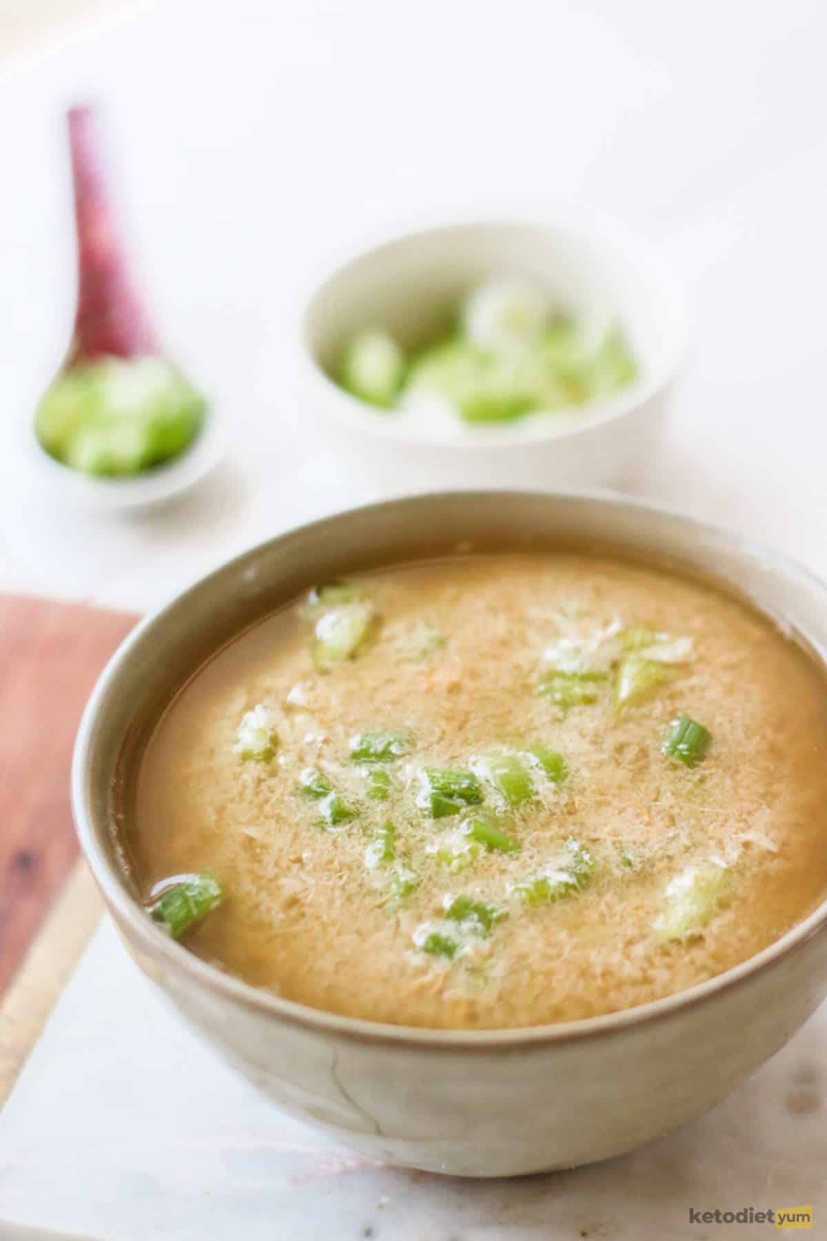 Delicious keto egg drop soup served in a bowl and topped with fresh green onions ready to enjoy