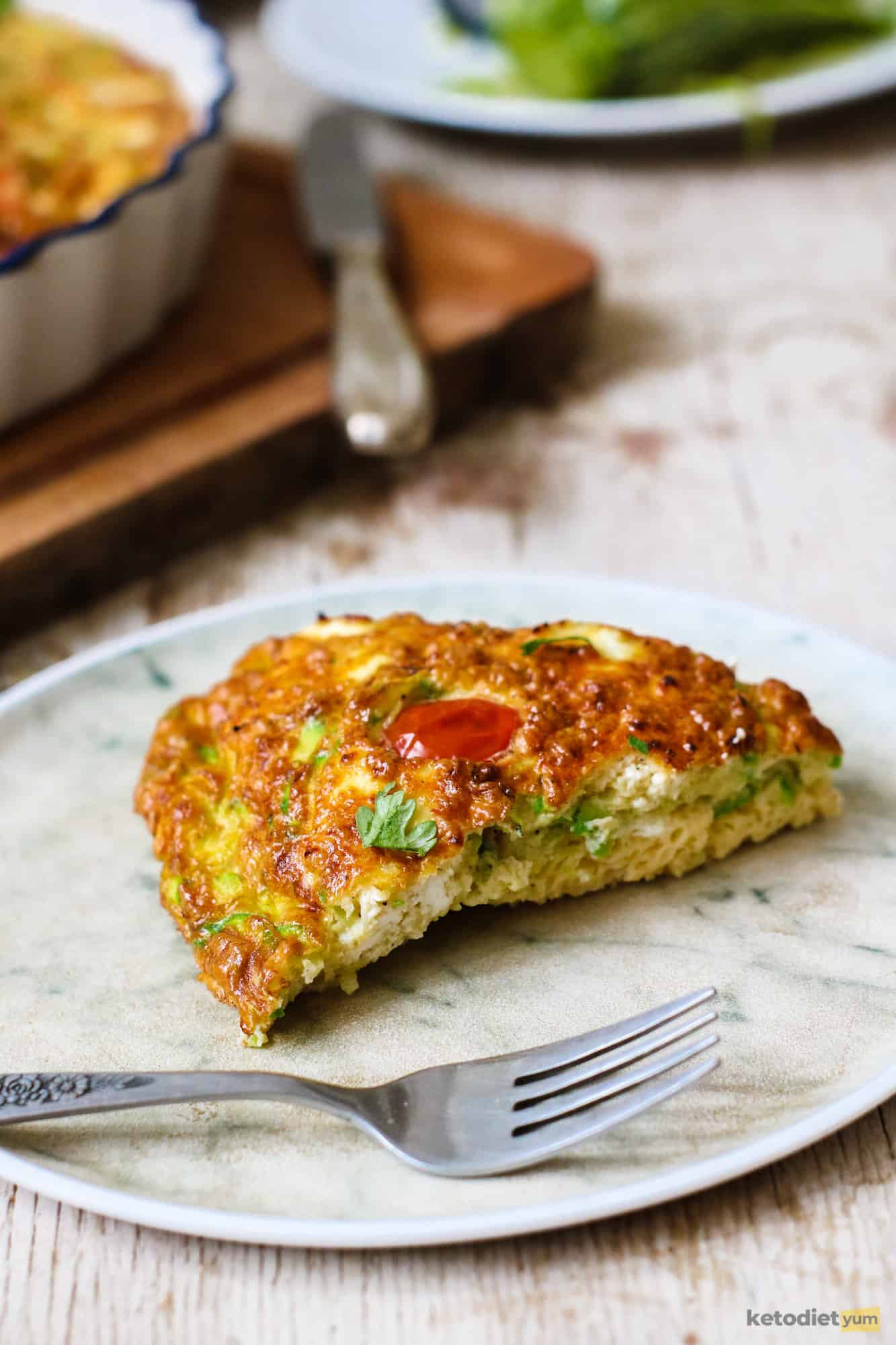 A slice of low carb frittata made with zucchini, goat cheese and cherry tomatoes